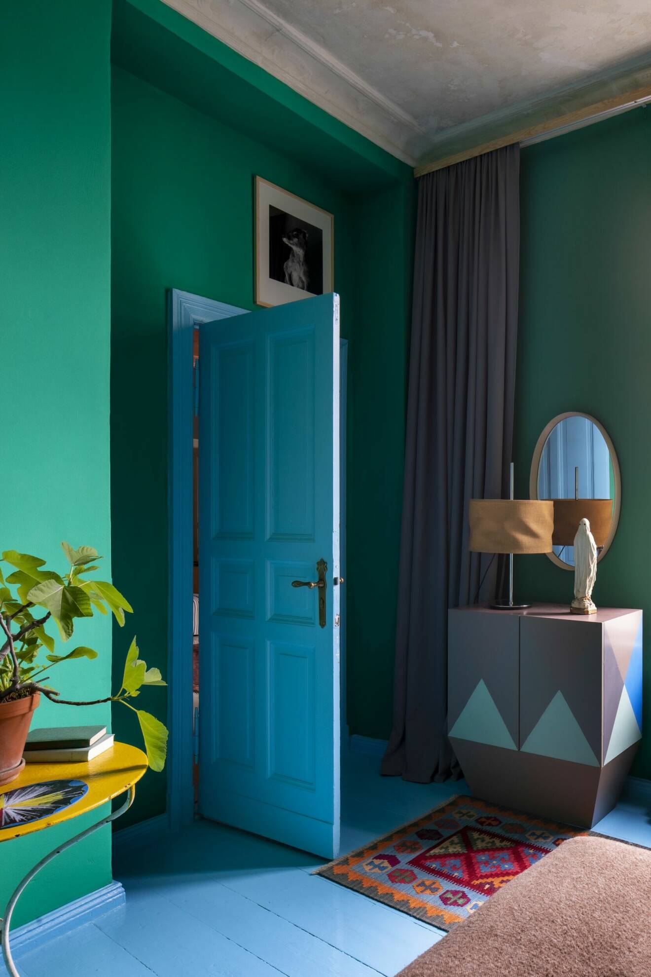 Gröna väggar, blått golv och blå dörr i färggrant hem