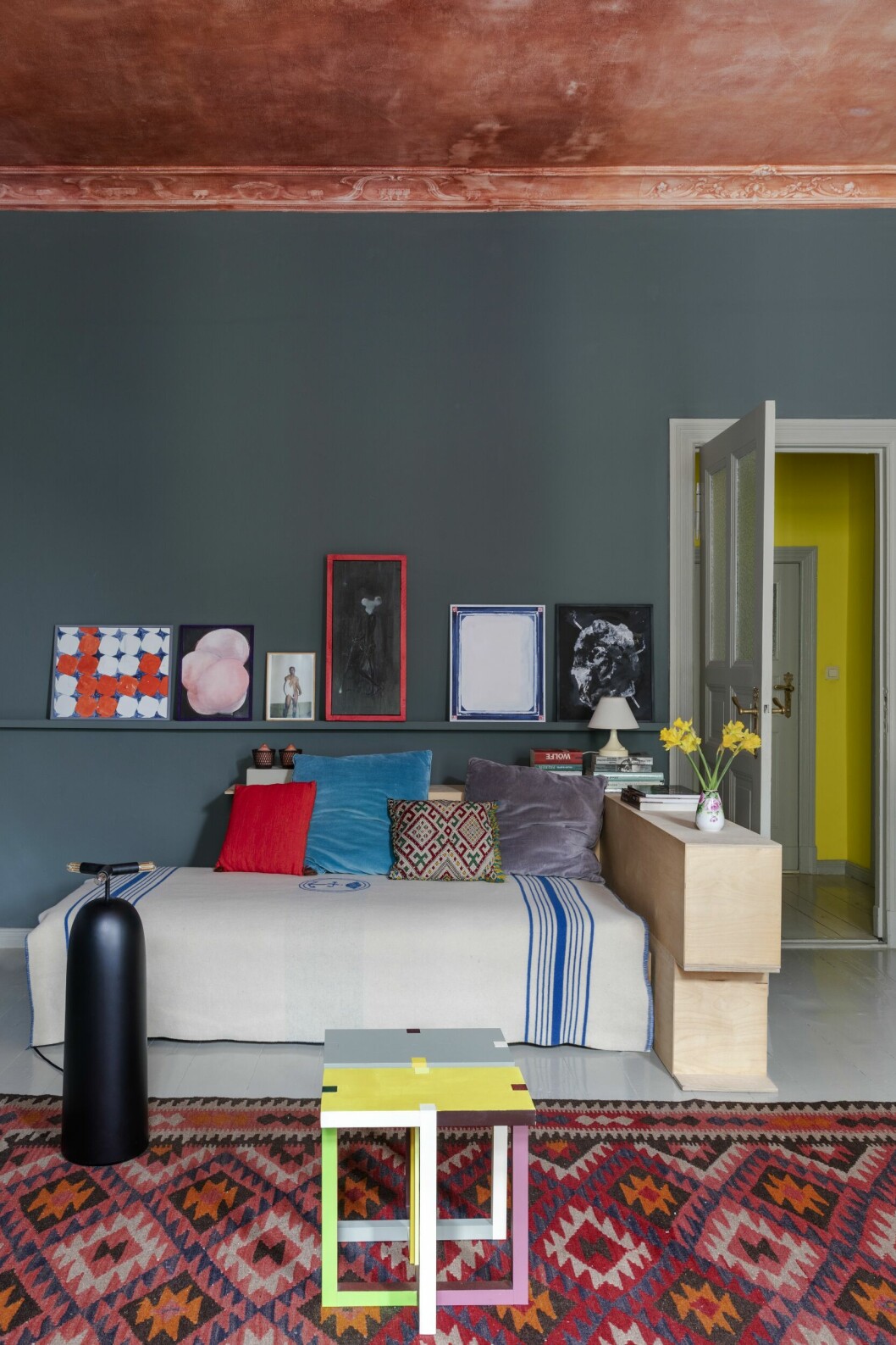 Soffbordet <em class="">Lake</em>, Martin Holzapfel Design, 2019. Soffan är vintage, köpt i Frankrike. Målningen <span class=" italic" data-lab-italic_desktop="italic">Der große Kegelhund</span>, av Jürgen Eisenacher, 2014. Skultpur på bordet, Nane Stegt. Skulptur vid fönstret, Nandor Angsten-berger. Lampa, <em class="">Parentesi</em>, av Achille Castiglioni och Pio Manzu för Flos Parentesi. Vägghylla, <span class=" italic" data-lab-italic_desktop="italic">Window 5 pm</span>, Martin Holzapfel Design. målat tak och inspirerande lägenhet i berlin