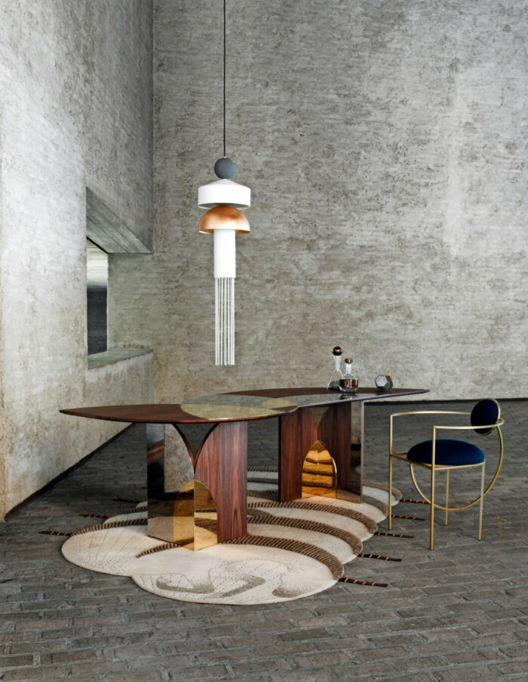 Matta <em>Terra Incognita</em> av Tulpar van Faberhama, Nodus. Matbord av Selène van Emmemobili. Lampa <em>Nappe XL1</em> av Marco Zito, Masiero. Karaff och whiskyflaska, Tank. Ljuslykta <em>Etch</em>, Tom Dixon. Stol <em>Lunar</em>, Matter of Stuff/Bohinc Studio. Matbord från Sèlene van Emmemobili på en naturmönstrad, geometrisk matta i grått rum