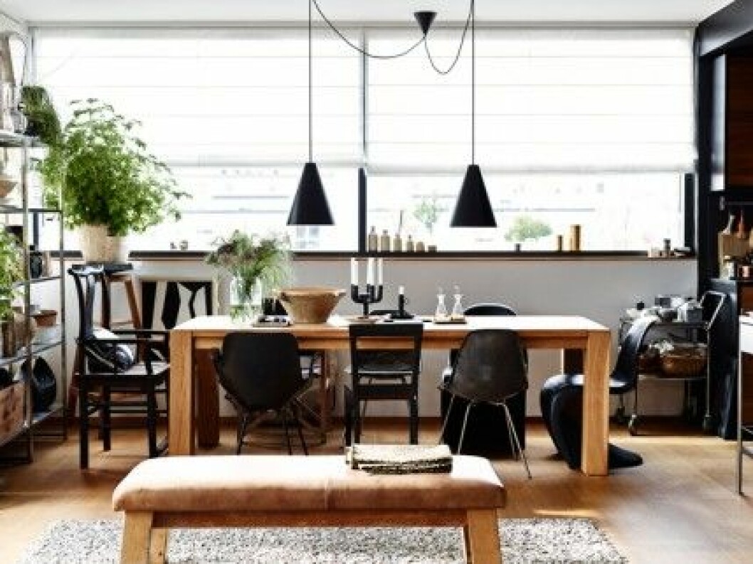 matbord, stolar, soffor, vä Matbordet står i den ena änden av det stora rummet, till höger ligger den lilla kökskuben. Bord från Crate & Barrel, stolarna är en blandning av Verner Panton, Eames, Habitat och arvegods. Lamporna är från Ikeas 365+. Den svarta kandelabern på bordet är av Ineke Hans, kammarljusstaken kommer från Ikea. Det stora skålen i keramik är fransk och köpt på Fil de Fer i Köpenhamn. matplats-rustikt-bord-svart-ek foto andrea papini