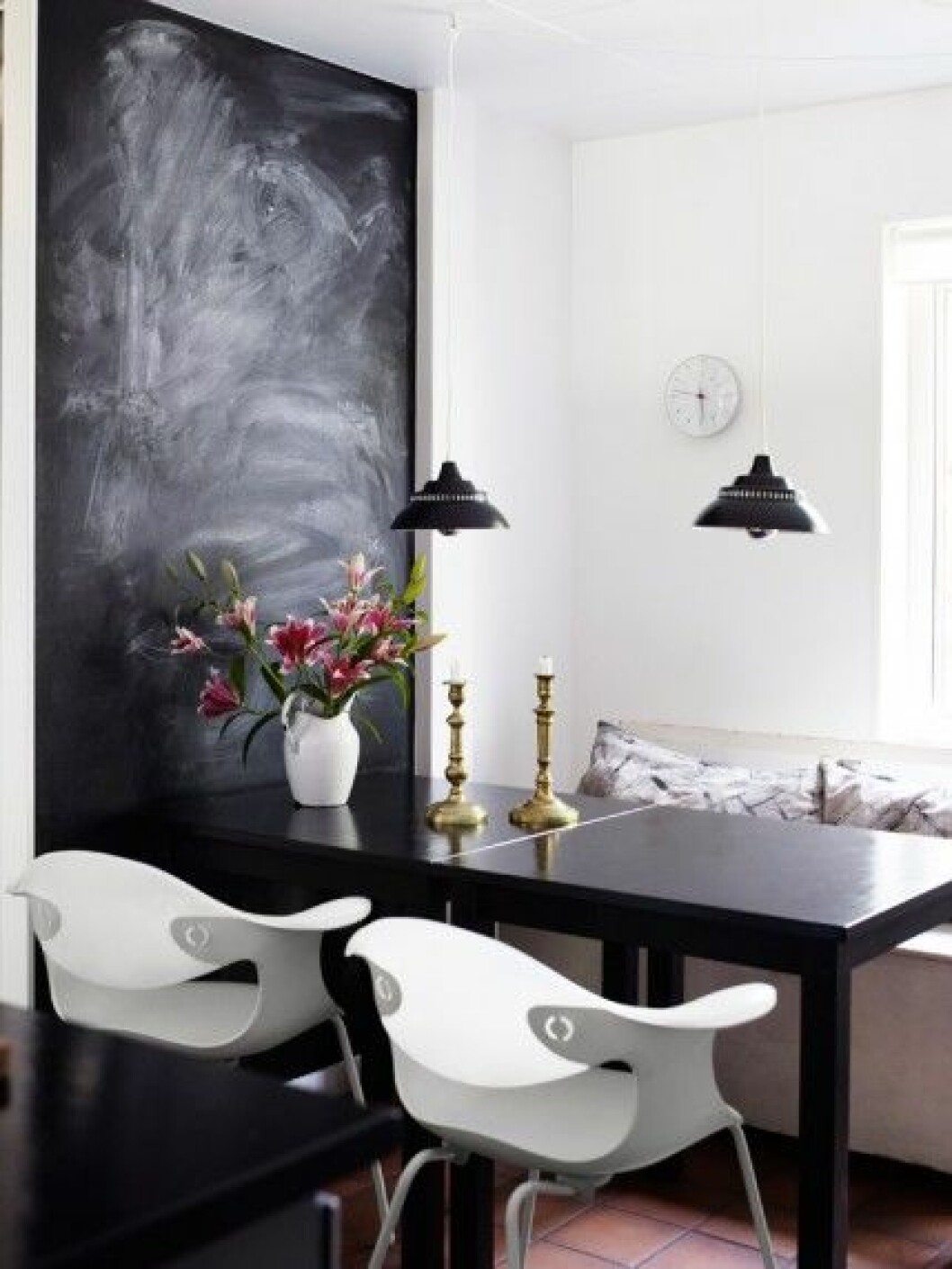 En vägg i köket fungerar som skrivtavla. Stolar <em>Bluebell</em>, design Ross Lovegrove för Driade. Väggklocka <em>Bankers Clock</em> från Rosendahl, design Arne Jacobsen. matplats-svart-tavla-inspiration-foto-anna-kern