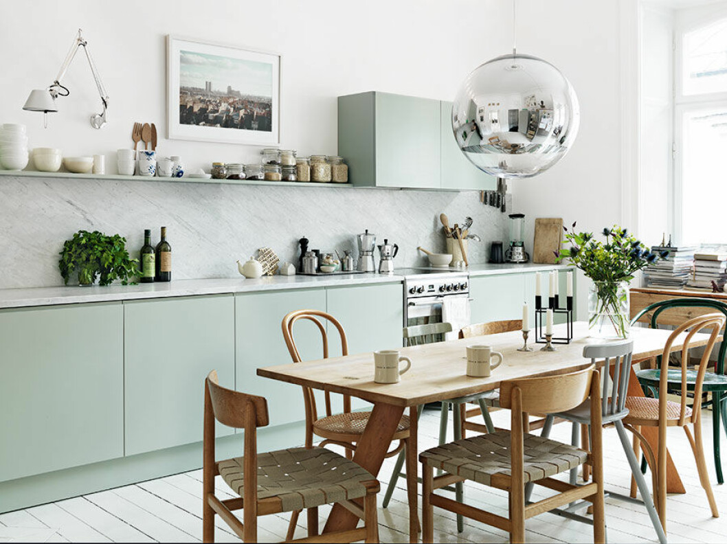 Foto: <a href="http://www.petrabindel.com/">Petra Bindel</a> Bilden publicerades ursprungligen i hemma hos-reportaget <a href="https://www.elle.se/decoration/ett-av-tidernas-mest-inspirerande-hemma-hos-reportage/">”Kika in i stylistens hem med det helt perfekta köket!”</a> Ovanför matbordet hänger lampan Mirror Ball av Tom Dixon. Den svartlackade stålljusstaken Kubus designades på 1960-talet av Mogens Lassen och finns fortfarande i produktion.