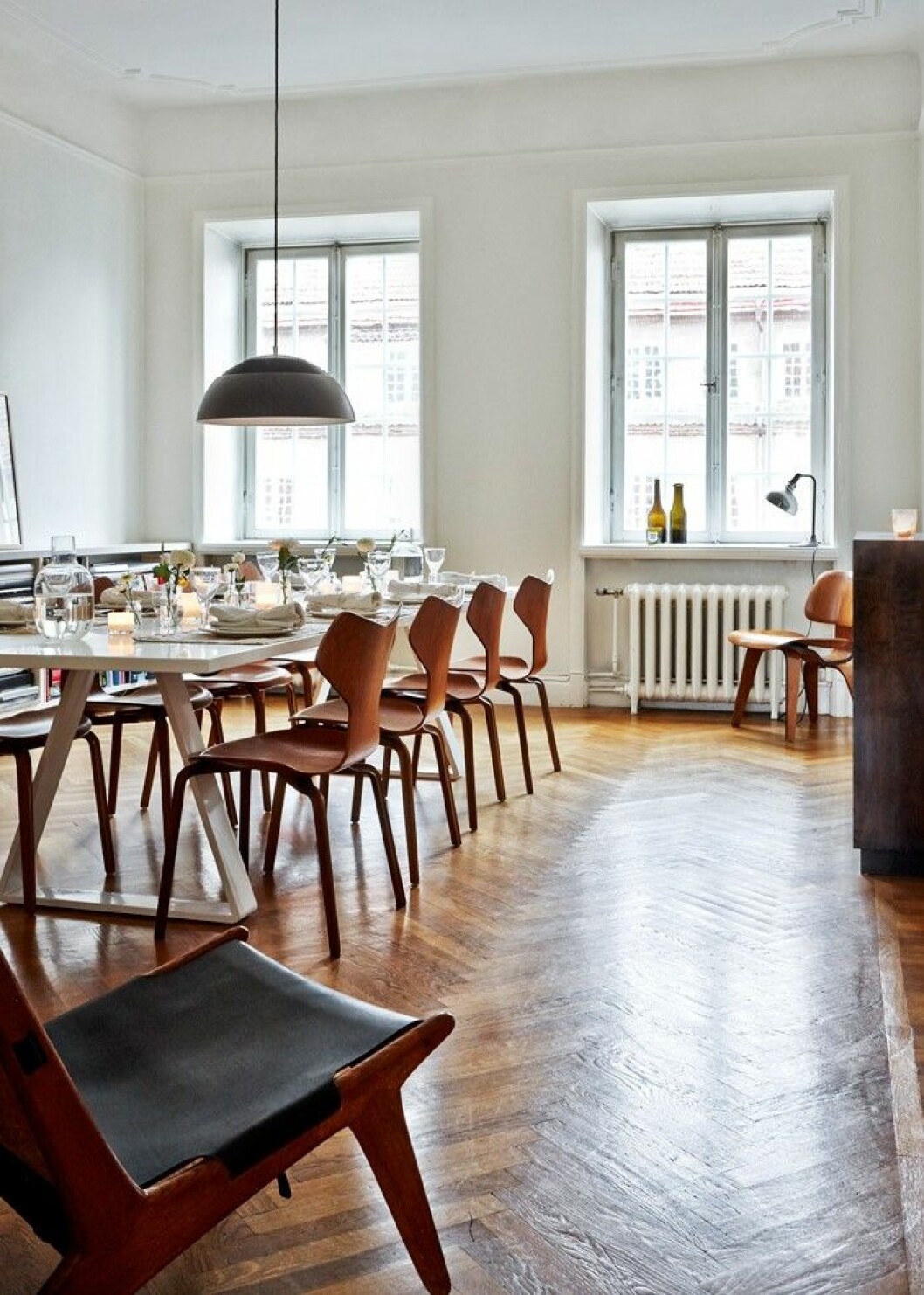 Arkitekten Thomas Eriksson ritade matsalsbordet åt Evelina och maken Stefan, innan bordet började produceras av Asplund, under namnet <em>Bermuda</em>. Stolar <em>Grand Prix</em>, design Arne Jacobsen, Vitra. Karaffer, design Carina Seth Andersson, Hope. Taklampa <em>AJ Royal</em>, design Arne Jacobsen, Louis Poulsen. En rymlig matsalsplats.