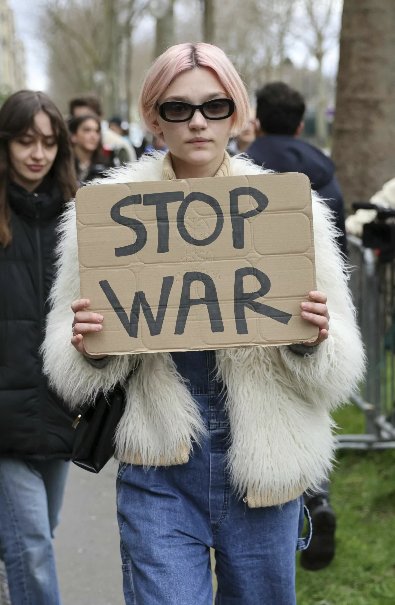 modell med protestskylt under modeveckan där det står "stop war" mot kriget i ukraina