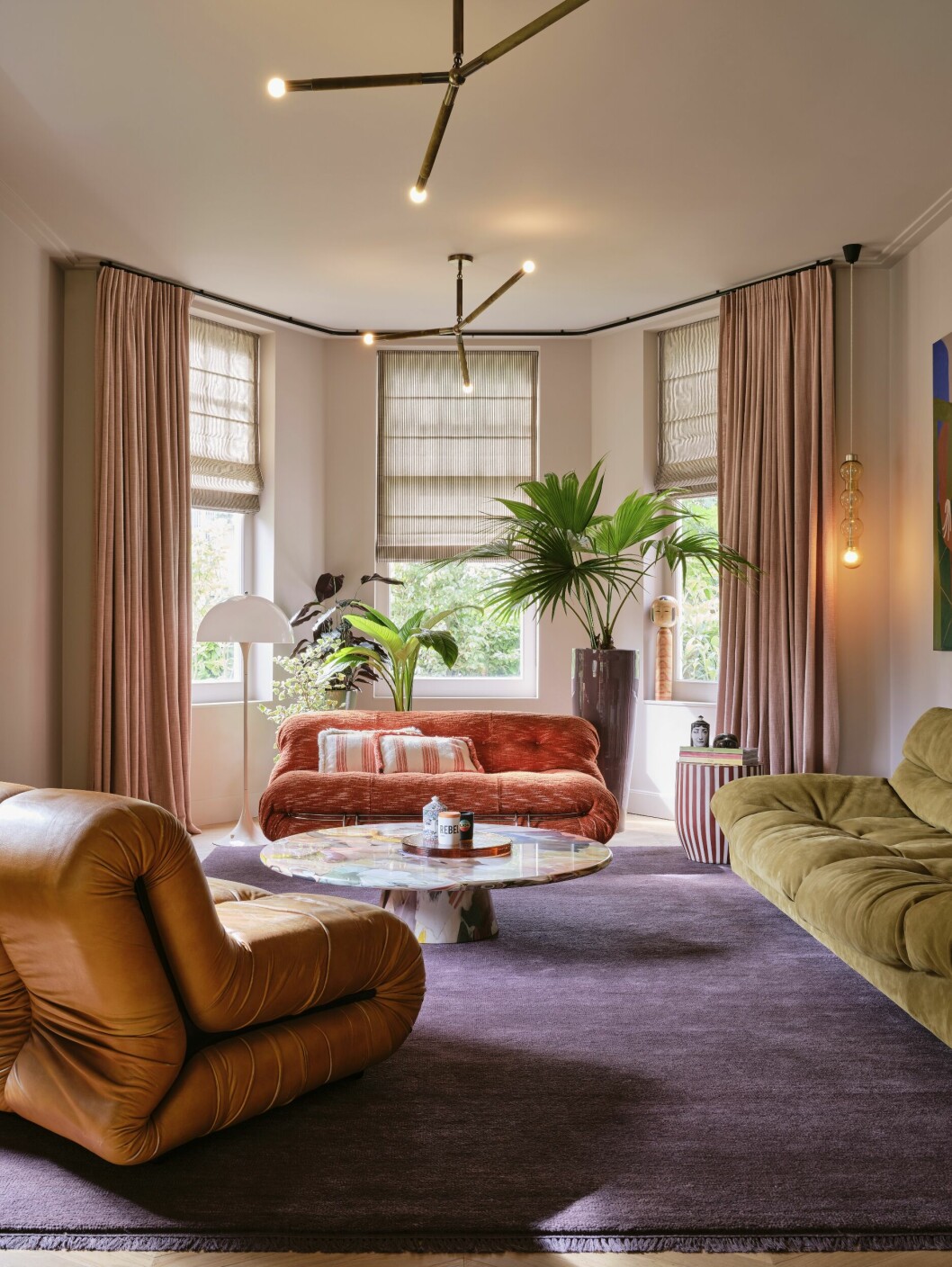 Läderfåtölj, Siton Vintage. Soffbord, Dirk van der Kooij, soffa till höger, <em>Milano</em> i kiwi nubuck, Baxter. Vintagesoffa vid fönstret, <em>Soriana</em> i tyget Sahara orange, Larsen. Randigt sidobord, Atelier ND Interior. Golvlampa, <em>Panthella</em> av Louis Poulsen. Pendellampa, Eclectic-20. Väggfärg, specialutformad av IJM Studio. Taklampor, Apparatus. vardagsrum hemma hos skådespelaren carice van houten