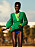 Modellen har på sig en mörkgrön klänning med en ljusgrön topp under och blåa bikinitrosor