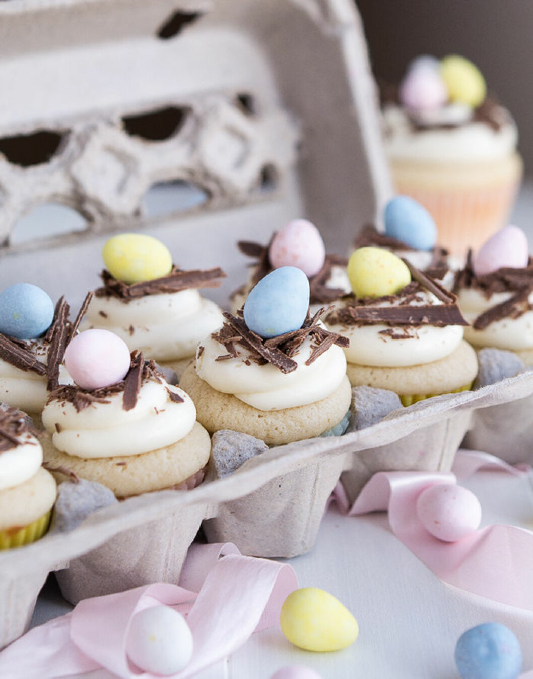 Cupcakes med riven choklad och pastellägg. Foto & recept: <a href="http://www.garnishandglaze.com/2015/03/09/white-chocolate-easter-egg-cupcakes/" target="_blank" rel="noopener">Garnish and glaze</a> Cupcakes med riven choklad och pastellägg.