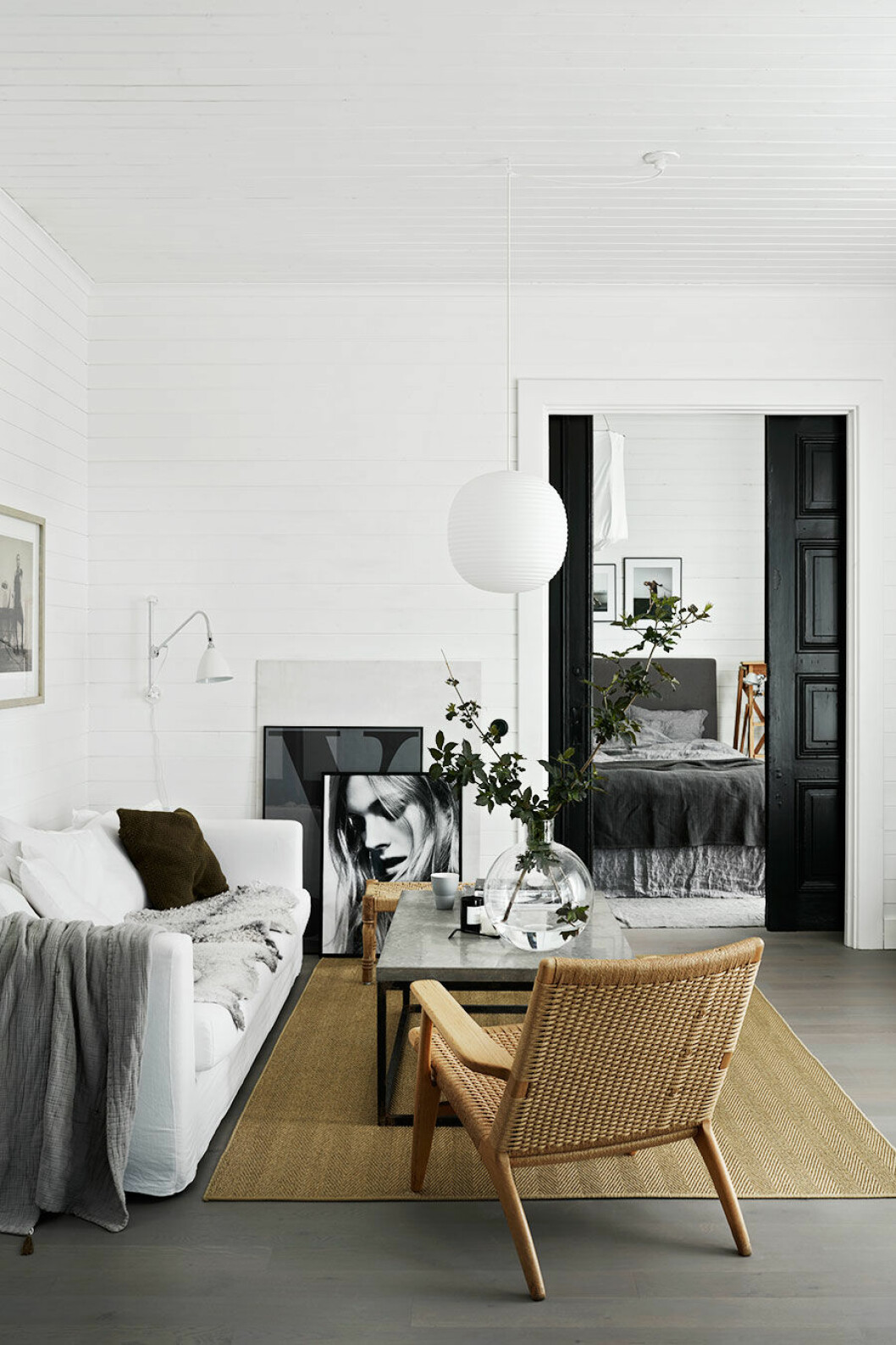 Foto: Kristofer Johnsson<em> </em>, styling: Pella Hedeby. Syns i: <a href="https://www.elle.se/decoration/mjuk-minimalism-i-var-bloggare-pella-hedebys-supersnygga-hem/">Mjuk minimalism i stylisten Pella Hedebys snygga hem</a> Ljust vardagsrum med vit soffa, vardagsrum i betong och en klassisk fåtölj
