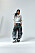 Modellen har på sig en kort vit jacka, från Isabel Marant, blus under från Acne Studios och byxor från The Attico.