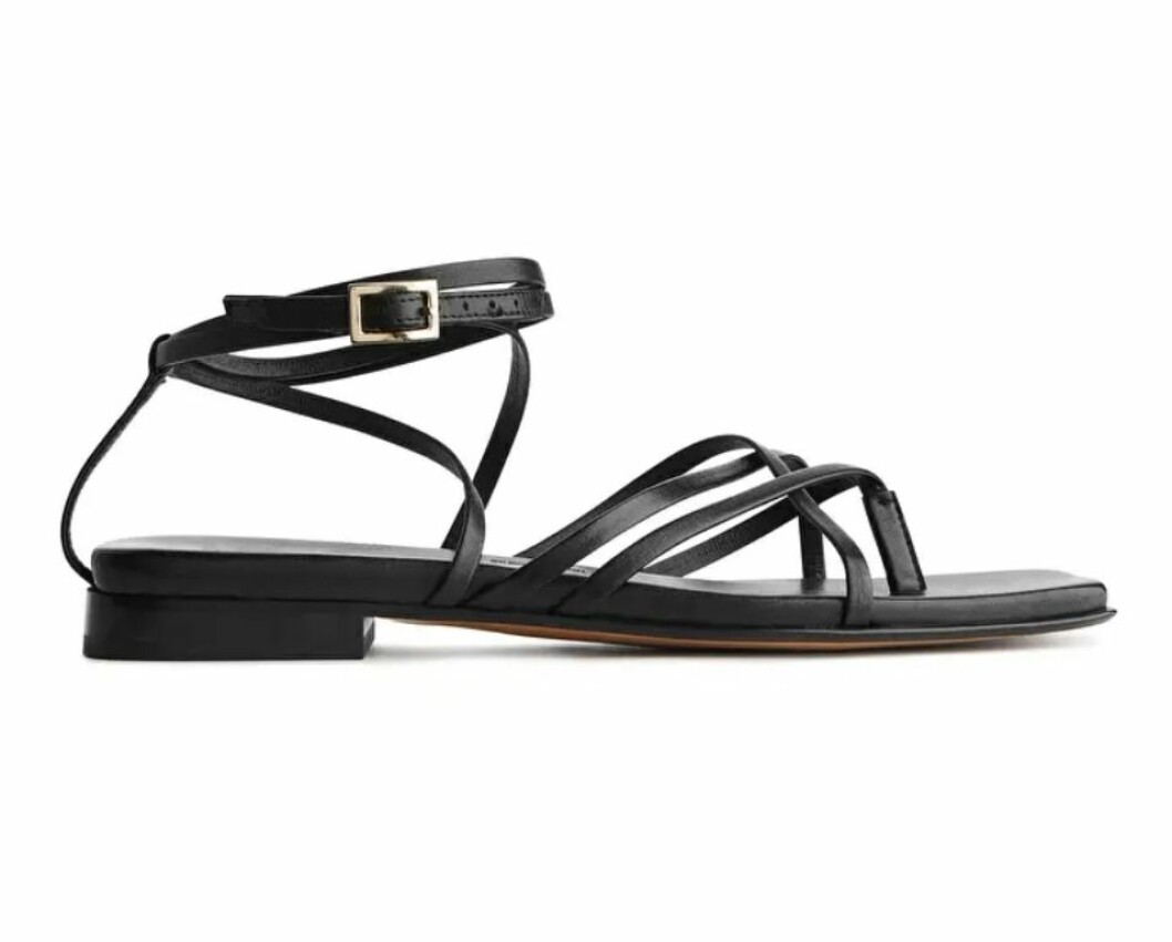 Dessa platta sandaler i svart med tunna remband och justerbart spänne från arket.