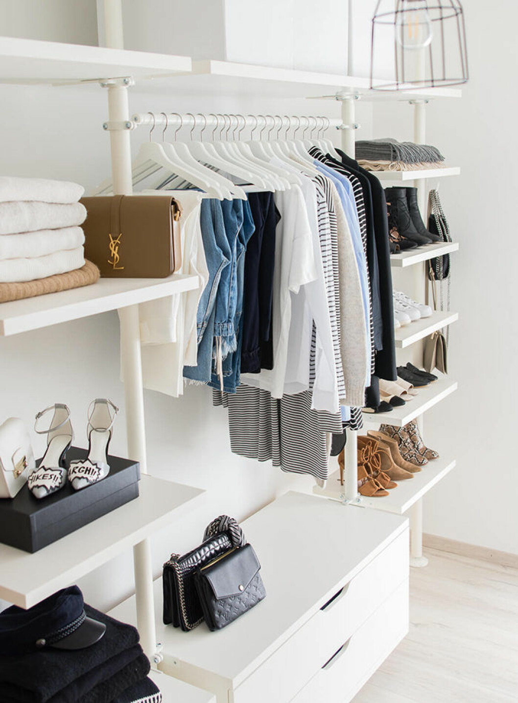 Foto: <a href="https://www.sarahvonh.com/2016-04-5-tipps-fuer-minimalismus-im-kleiderschrank/2/" target="_blank" rel="noopener">Saravonh.com</a> Walk-in closet med jeans, väskor och skor