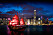 Hong Kong på kvällen med asiatisk röd båt