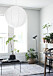 Stor lampa i rispapper i ett rum med balkong och växter