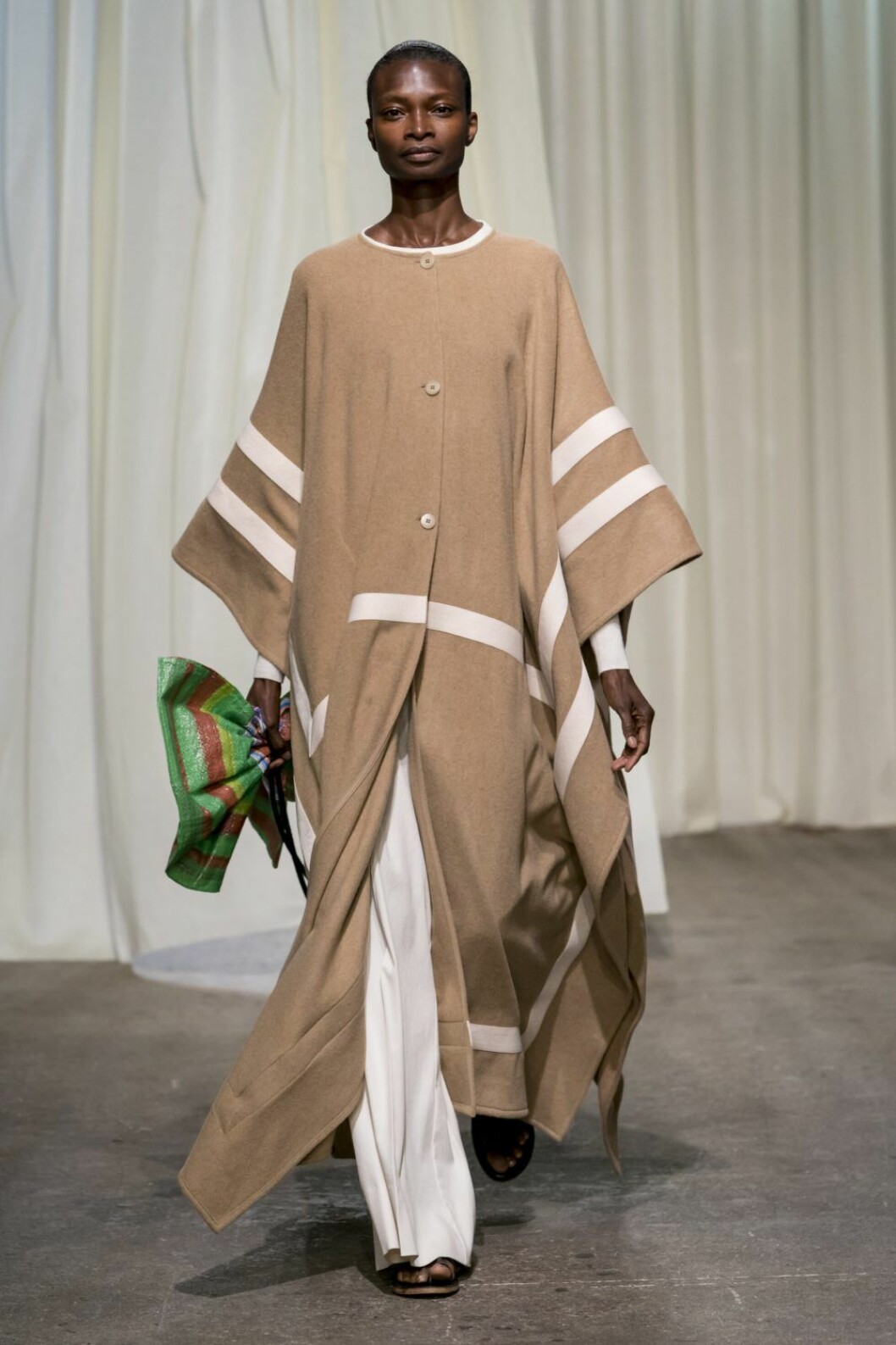 Rodebjer SS20, voluminös kappa i beige med vita ränder.
