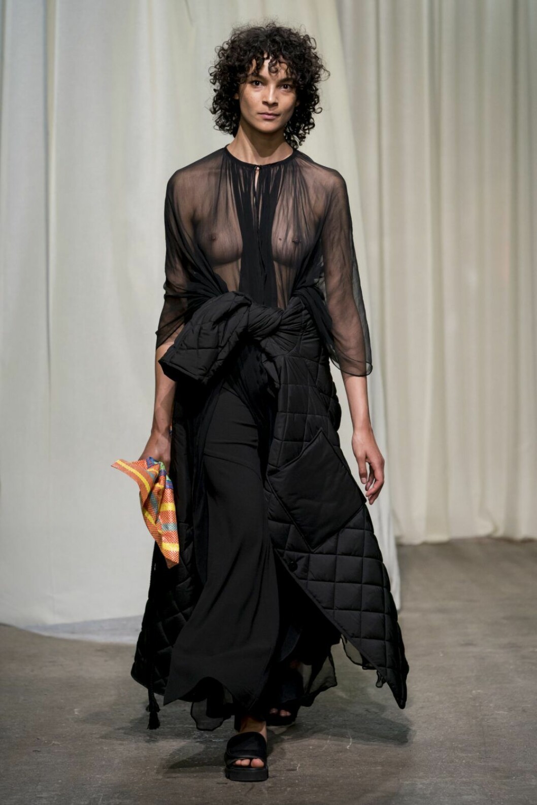 Rodebjer SS20, svart look med skir överdel och dunjacka kring midja.