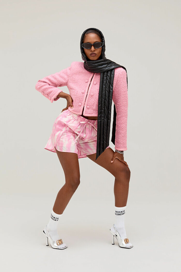 Den klassiska, preppy rosa jackan från Rotate går väl ihop med de eleganta silverklackarna – och möter en mer streetig look tillsammans med de vita strumporna och huvan. Rosa jacka, huva, silver