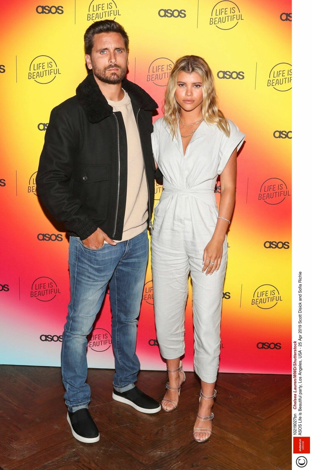Scott Disick och Sofia Richie står bredvid varandra och håller om varandra 