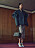 Modellen bär en kavaj, kjol, väska och pumps, allt i en stilkrock från Prada.