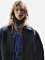 Närbild på modellen som har på sig en svart jacka från Teurn och en blå klänning från Akris