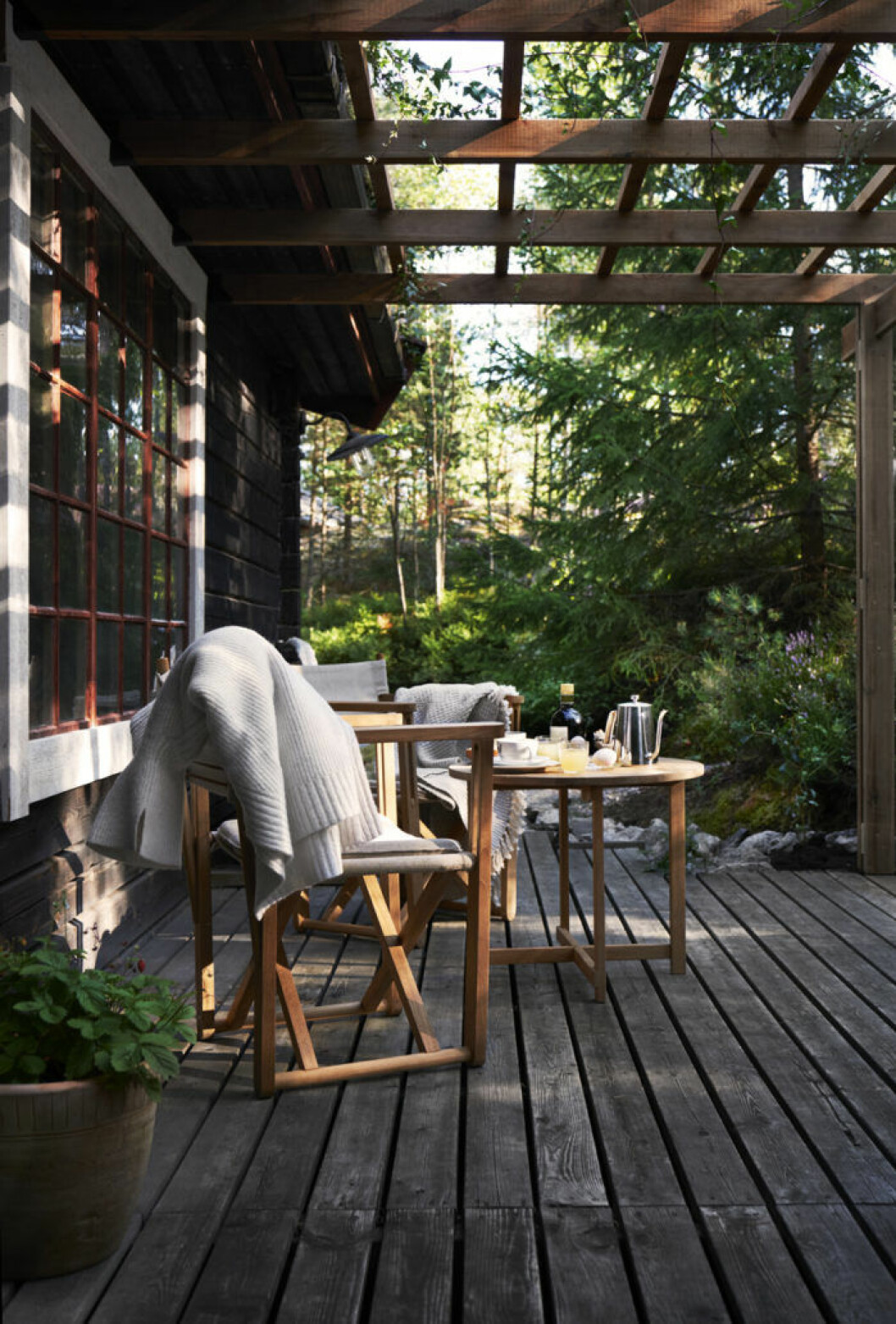 Uteplatsen under pergolan har sol på eftermiddag och kväll. Bordet och stolarna i teak och linne är modell Kryss från Skargaarden. Tanken var att fortsätta på safari- och regissörsstolstemat, som även återfinns inne i huset. Uteplatsen i huset.