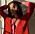 Chloé Schuterman står i solljus och bär en röd och rosa stickad kofta.