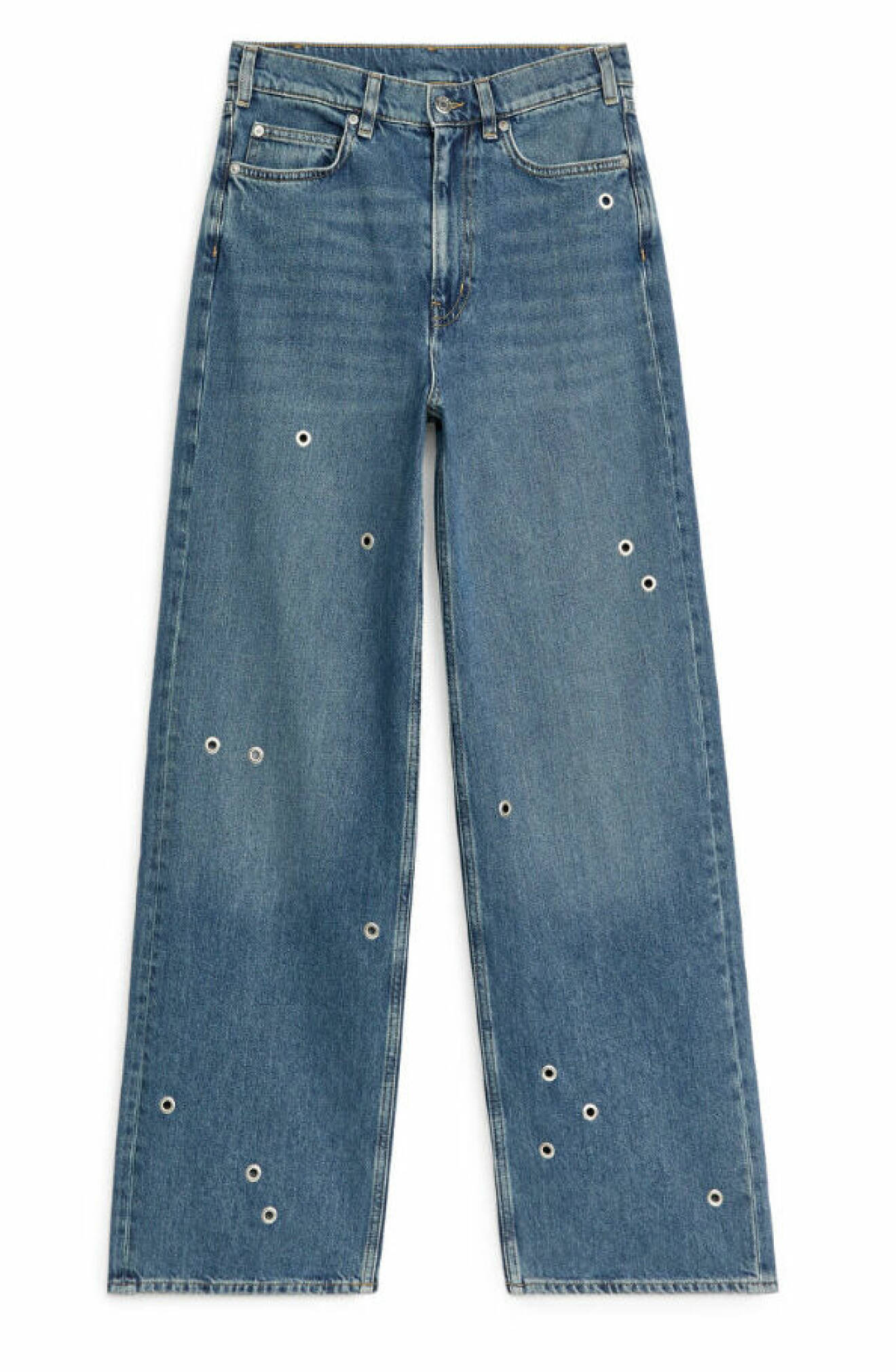Snygga jeans i blå tvätt med dekorativa öljetter från Arket.