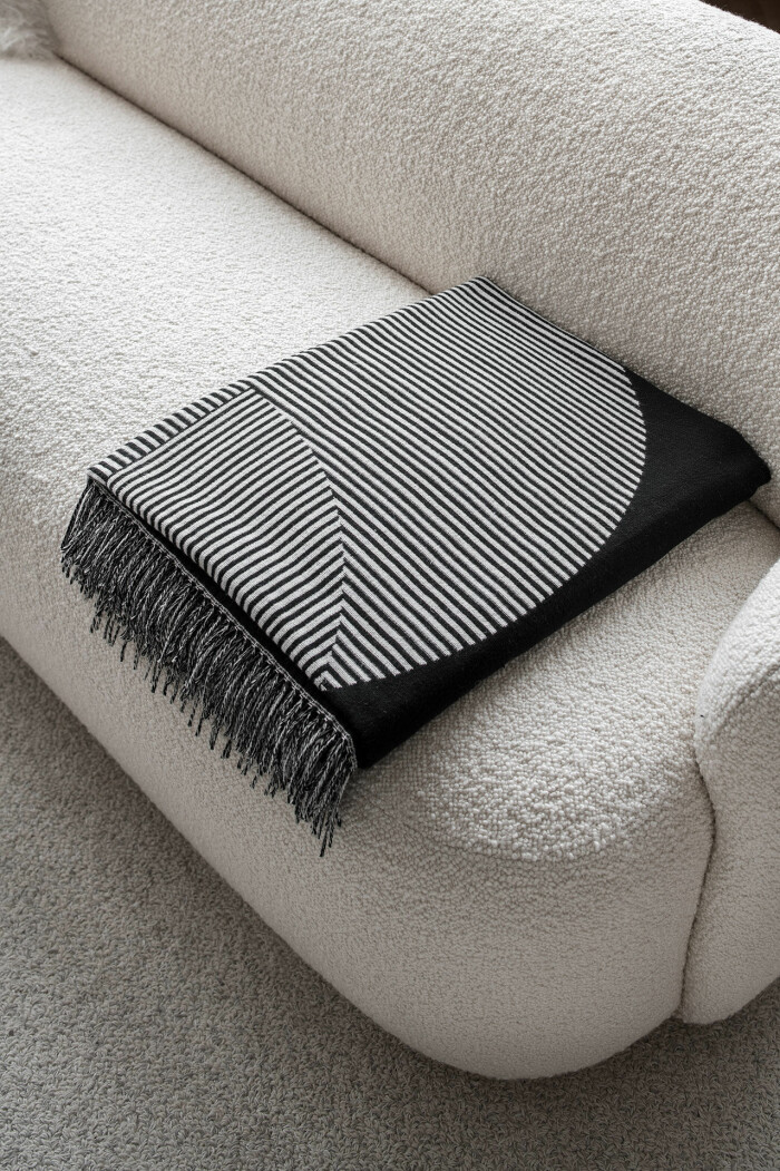 Bouclé och mjuk ull är självklara materialval tillsammans med de värmande plädarna. Foto: NJRD soffa i bouclé och pläd från NJRD
