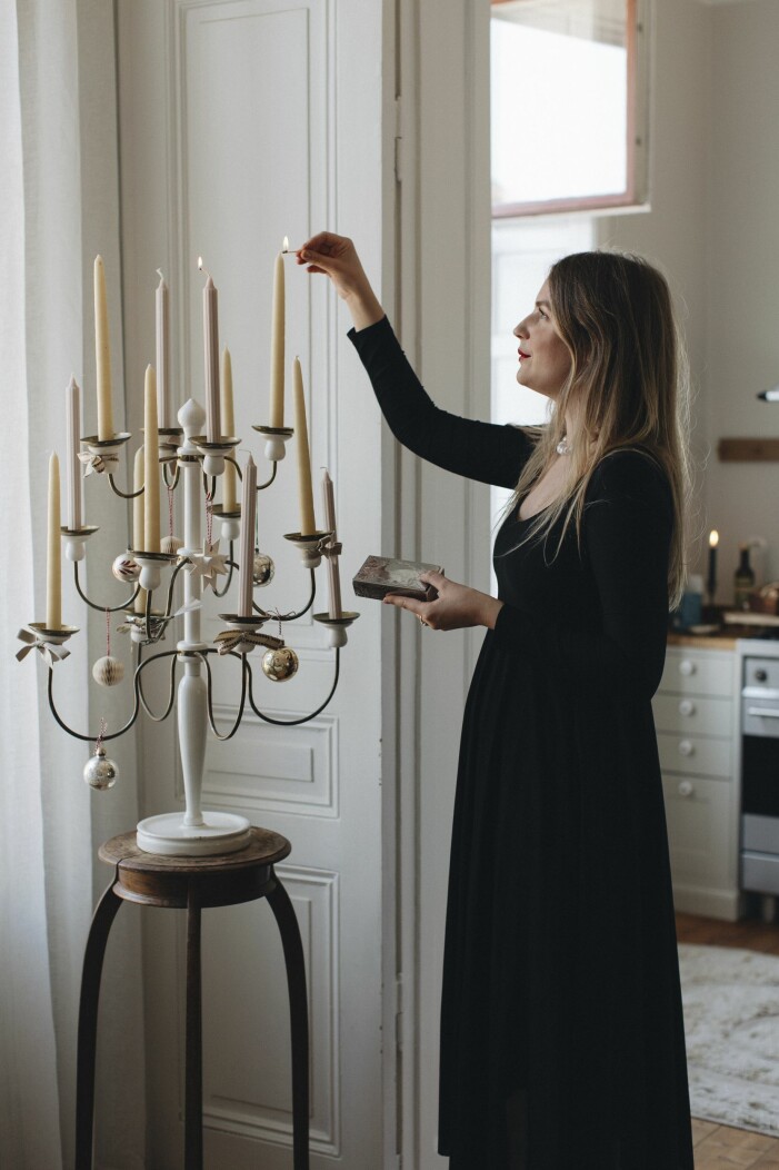 Sofia Wood tander honungsfargade ljus i en Josef Frank kandelaber