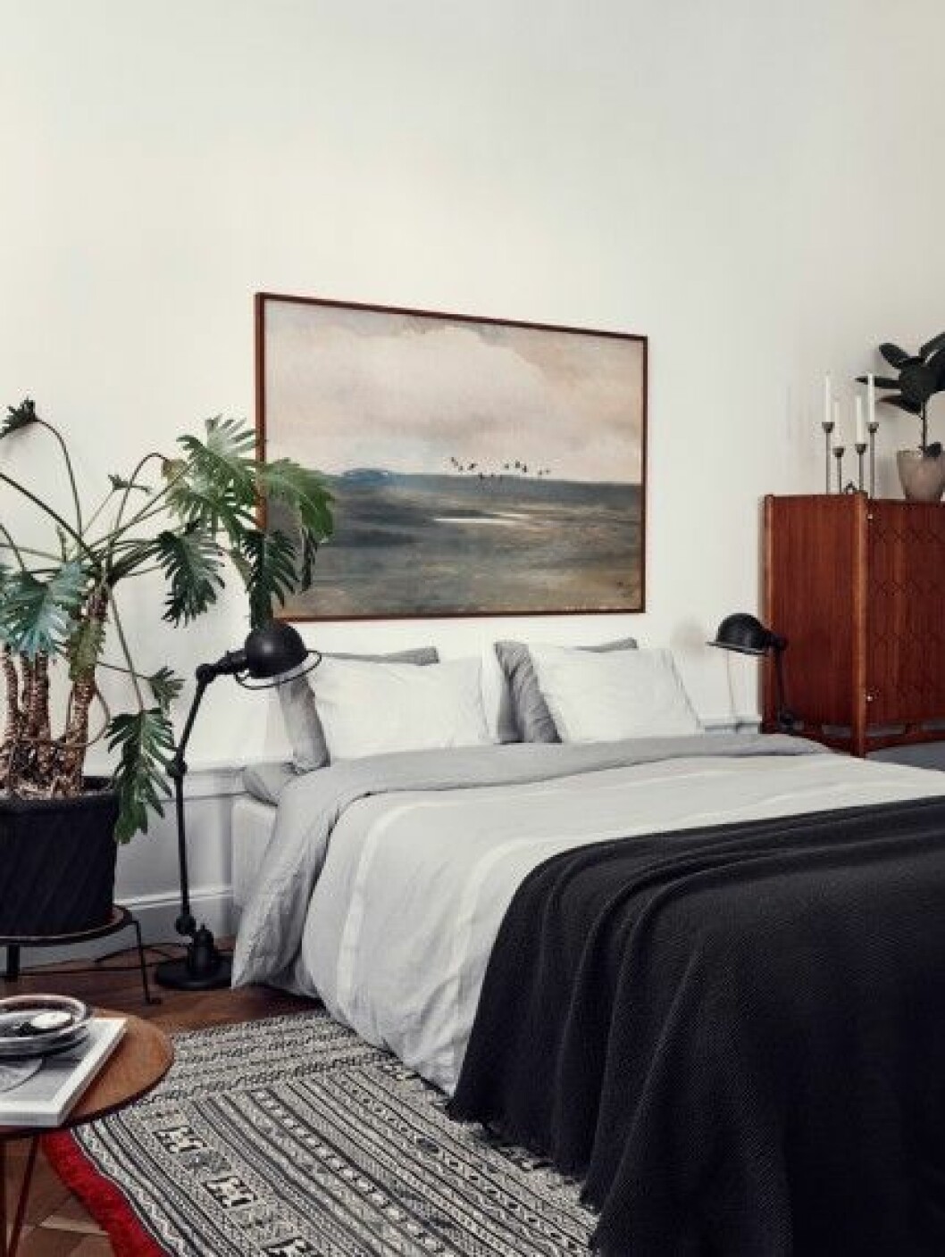 Bröstpanelen i sovrummet satte Joanna och David själva dit. Sideboard, design David Rosén, pläd från Society och lakan från Calvin Klein. Den antika mattan kommer från Marocko. ”Den luktade hemskt när vi först tog fram den, men efter några veckor försvann lukten plötsligt”, säger Joanna. Tavla av Lennart Sand. sovrum-mattor-tavlor-växter-inspiration