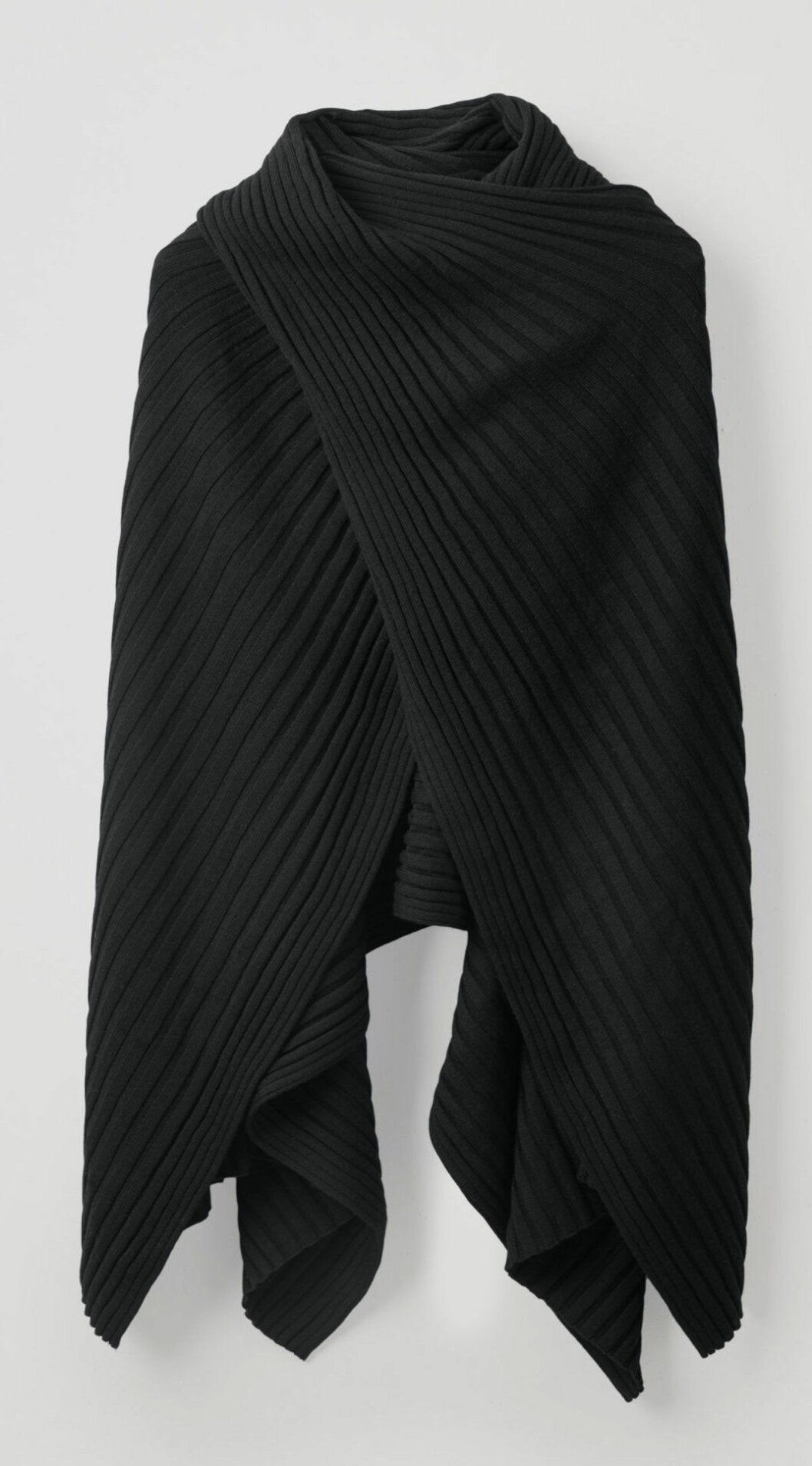 Svart ribbstickad poncho från COS.