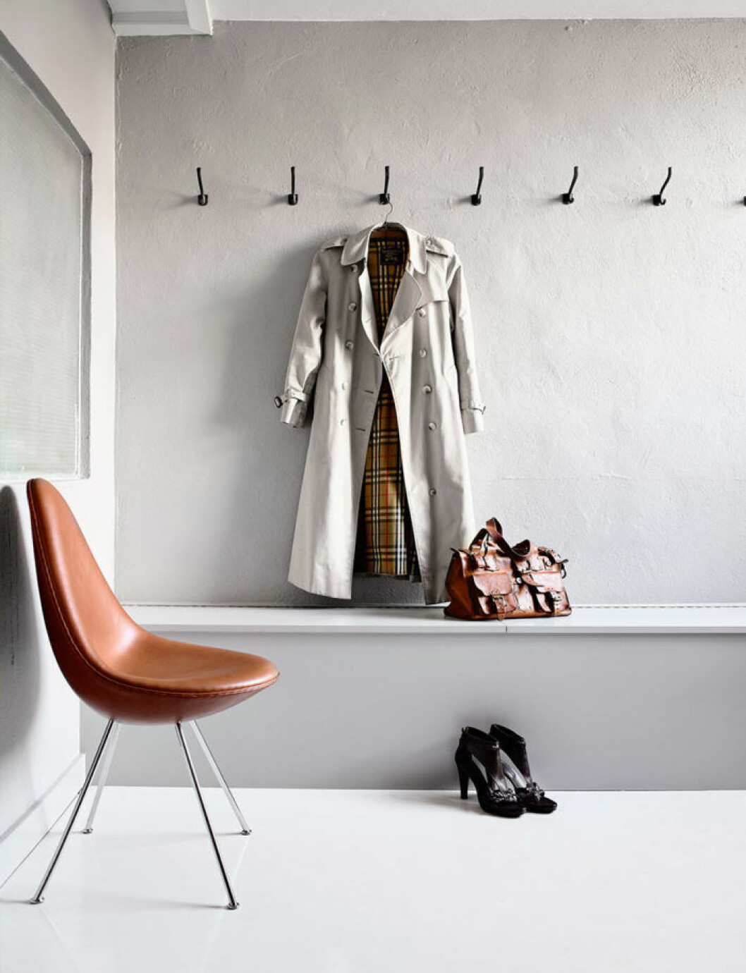 Av: Lise Septimius Krogh Foto: Kristian Septimius Krogh Syns i: <a href="https://www.elle.se/decoration/stilig-industristil-med-designklassiker-i-gamla-fabriken/">Stilig industristil med designklassiker</a> Sparsmakad hall med krokar på rad och en kappa hängandes.