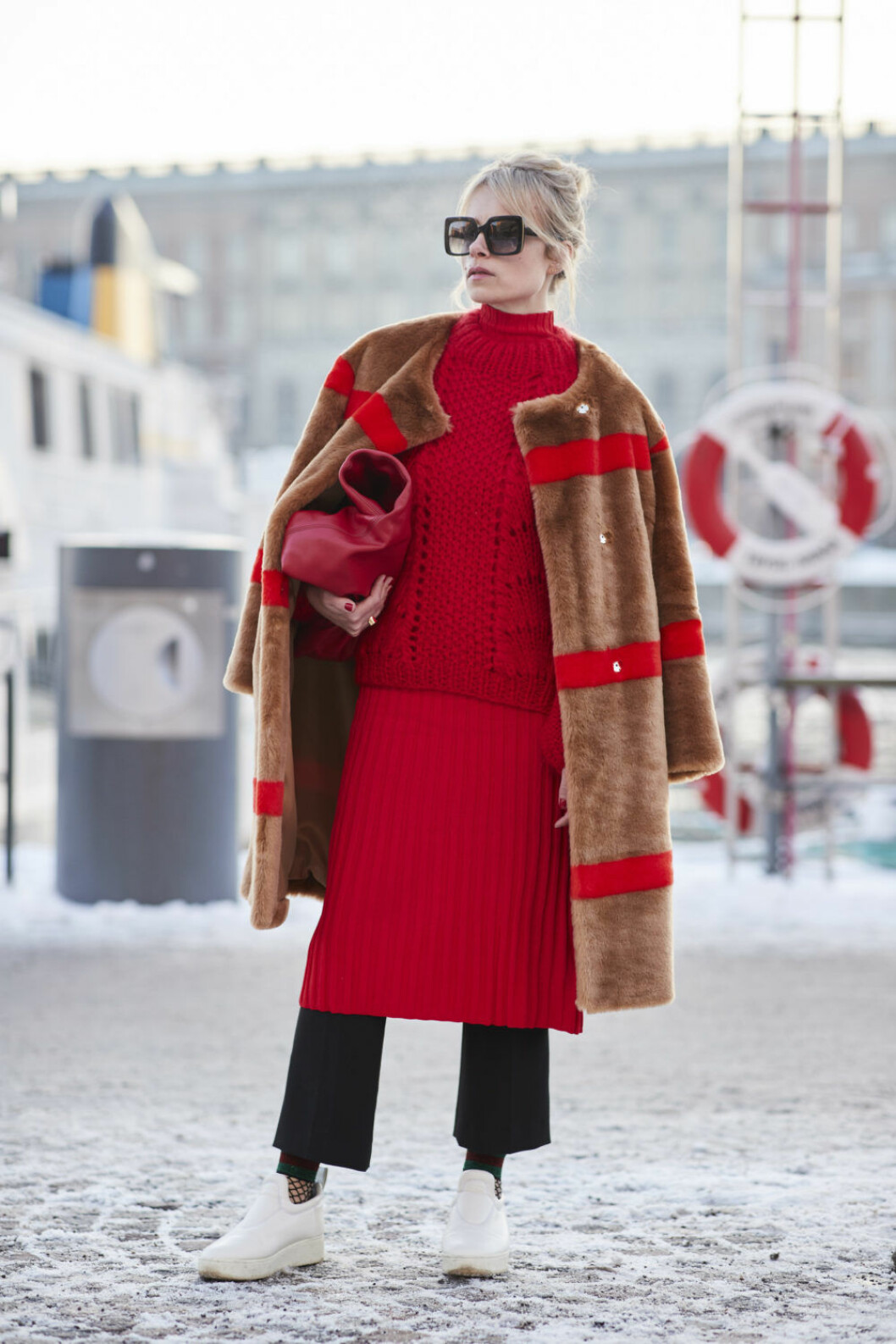 <img class="size-medium wp-image-250200" src="https://files.elle.se/uploads/2018/01/Stockholm-str-RF18-6105-800x1200.jpg" alt width="800" height="1200" srcset="https://files.elle.se/uploads/2018/01/Stockholm-str-RF18-6105-800x1200.jpg 800w, https://files.elle.se/uploads/2018/01/Stockholm-str-RF18-6105-1000x1500.jpg 1000w" sizes="(max-width: 800px) 100vw, 800px"> Kvinna i röd outfit och brun kappa med röda detaljer.