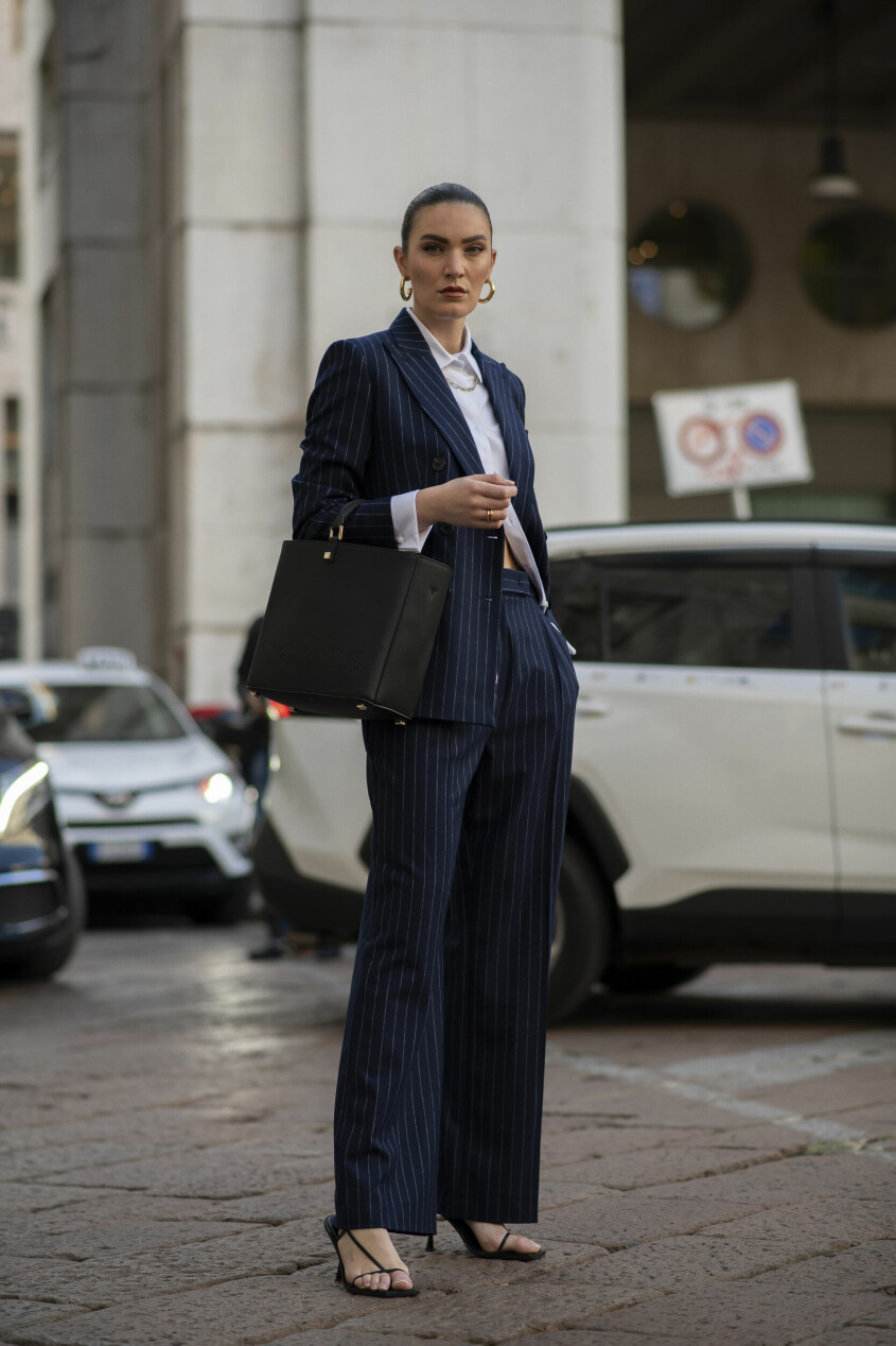 En marinblå kritstrecksrandig kostym, som här på Milano Fashion Week, går aldrig fel. streetstyle blå kritstrecksrandig kostym dam