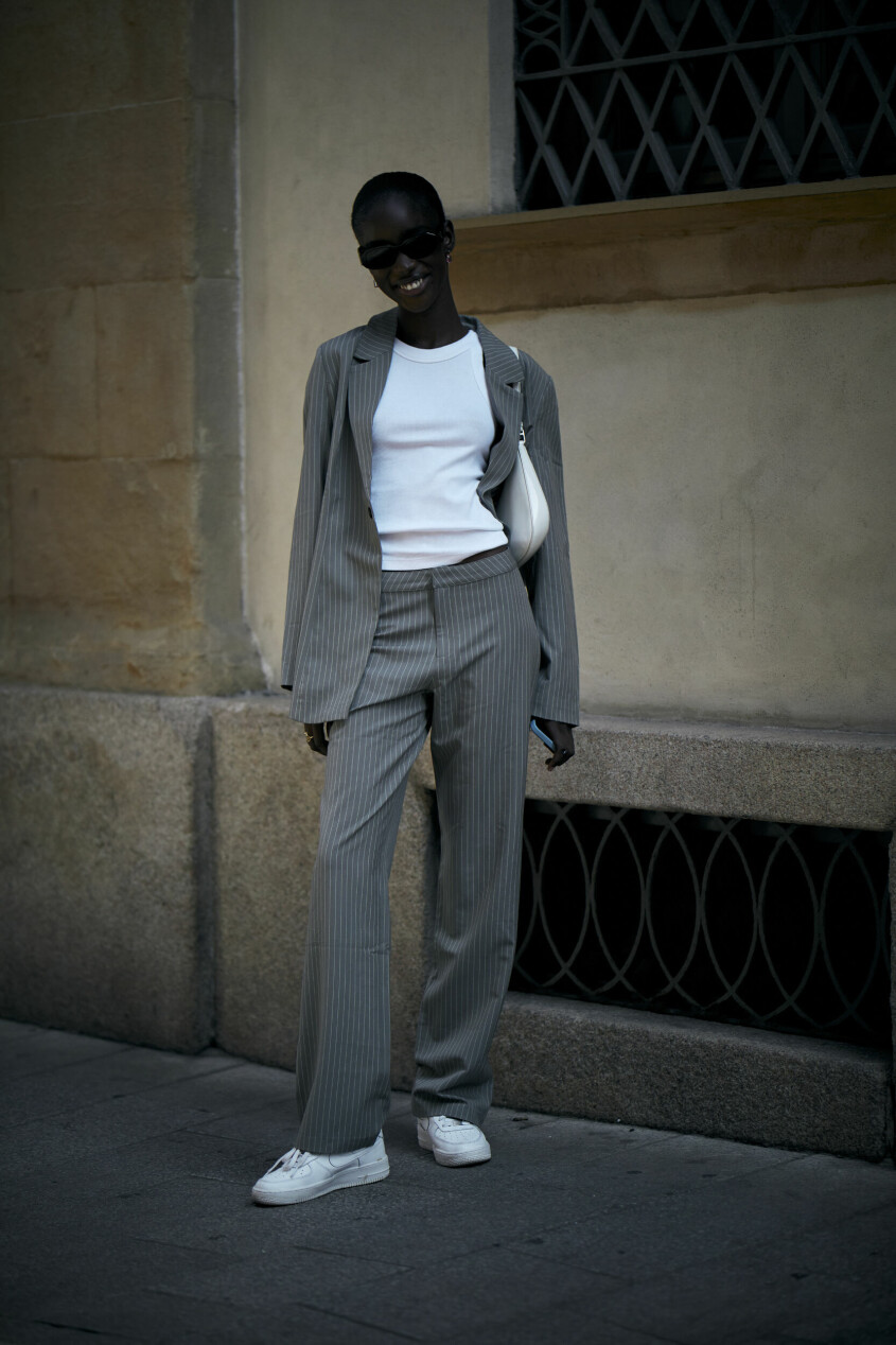Kritstrecksrandigt i avslappnad tolkning på Milano Fashion Week SS23. streetstyle grå kritstrecksrandig kostym dam