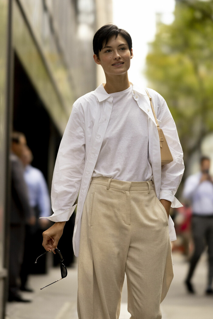 Den vita skjortan går att såväl klä upp som klä ned, beroende på tillfälle. streetstyle med beige kostymbyor, vit t-shirt och oversized skjorta