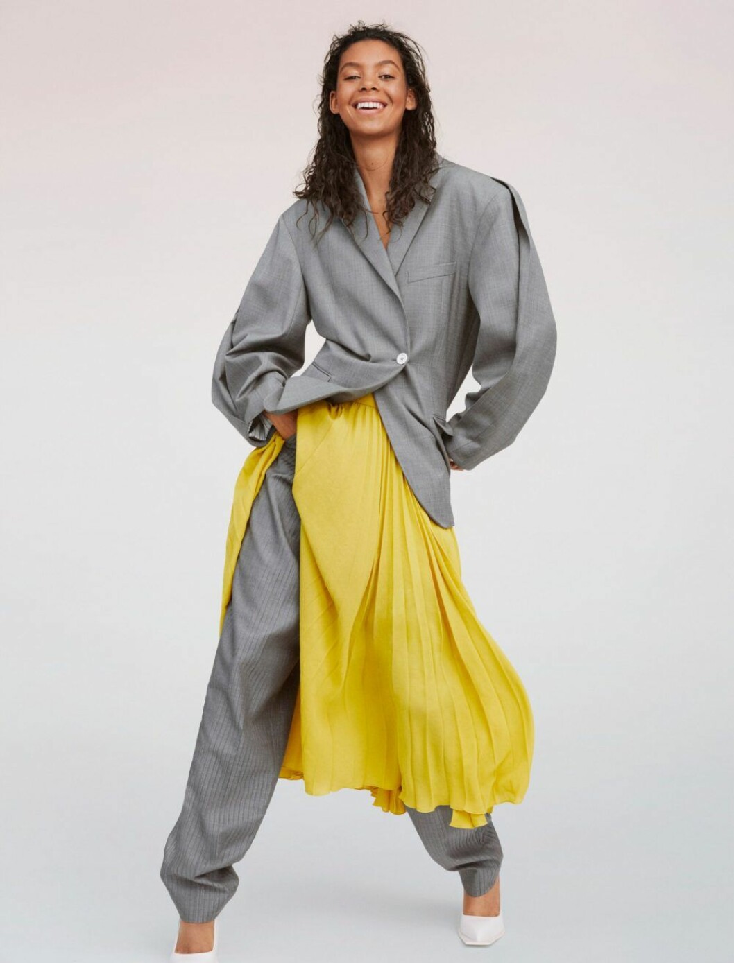 Kavaj, 8 300 kr, byxor, 5 700 kr, och skor, 4 800 kr, allt Acne Studios. Kjol, 5 242 kr, Dries Van Noten. Grå kostym med en gul färgklick – hösten 2019 är ton i ton den största trenden