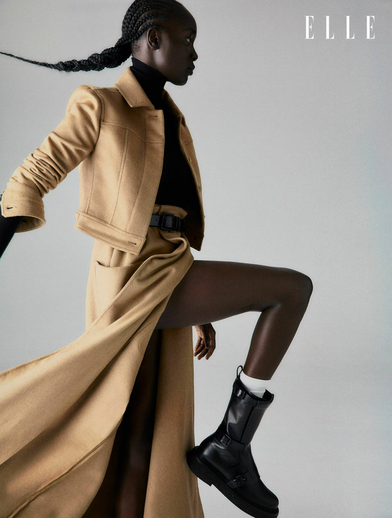Fotomodellen har på sig en matchande beige jacka och långkjol tillsammans med en svart polotröja, allt från Max Mara