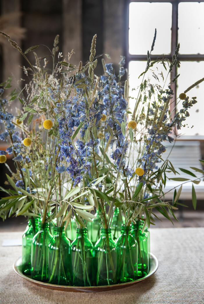 Med en bricka och flera små vaser får du enkelt till ett imponerande blomsterarrangemang. Torkade ängsblommor i vas