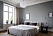 Sovrum med trendig bäddning i hotellstil med överkast i grått