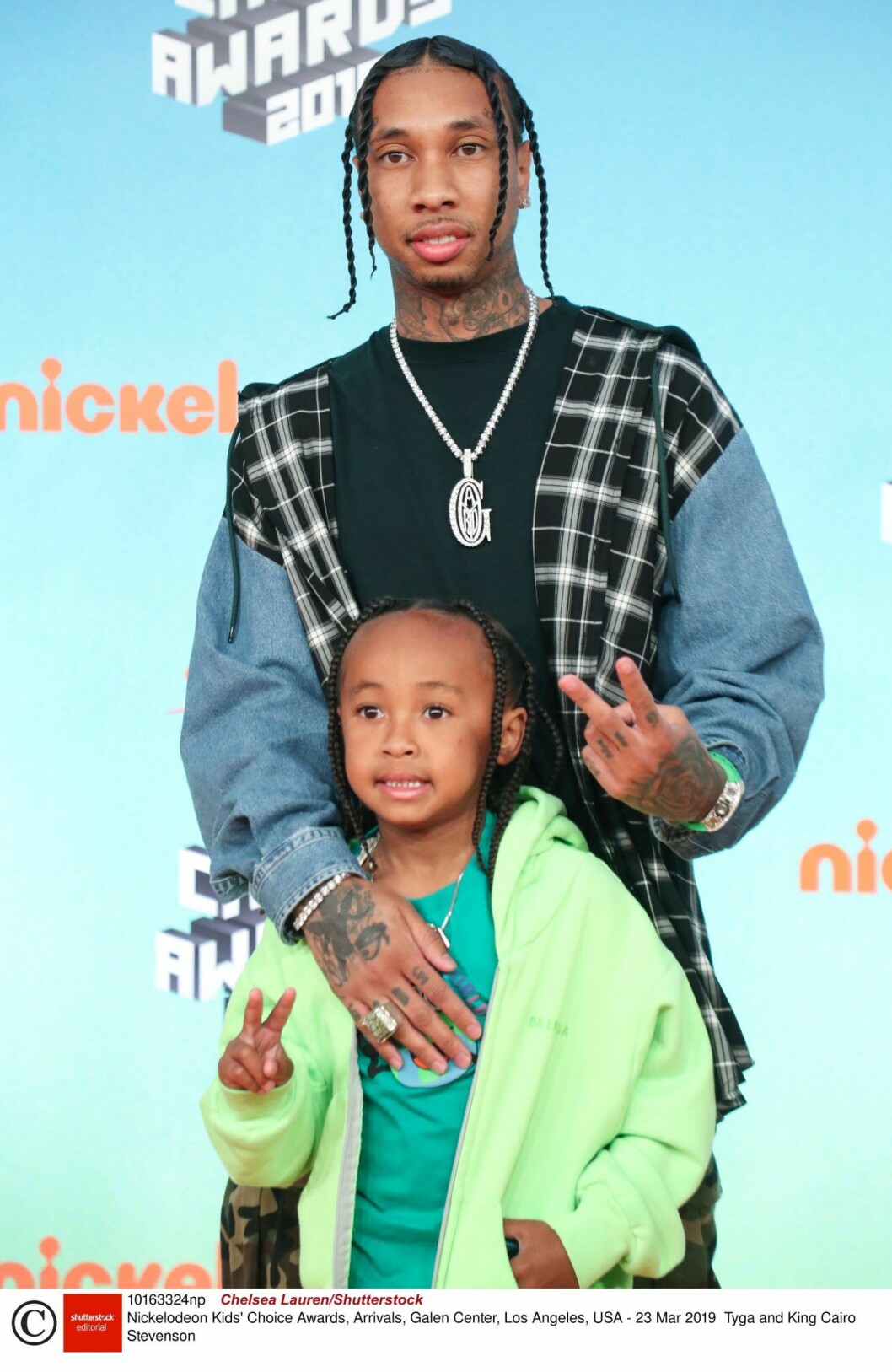 Tyga står bakom sonen King och håller om honom och de båda gör v-tecken med fingrarna