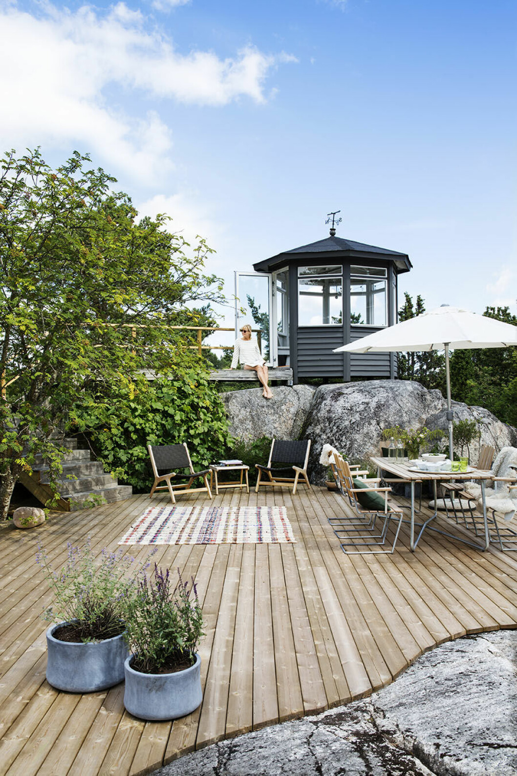 Syns i: <a href="https://www.elle.se/decoration/magnifik-utsikt-och-naturnara-inredning-i-sommarhuset/">”Naturnära inredning – och en helt makalös utsikt”</a>. Foto: Johan Sellén, styling: Gill Renlund. Uteplats i skärgården med platsbyggt trädäck mellan bergen