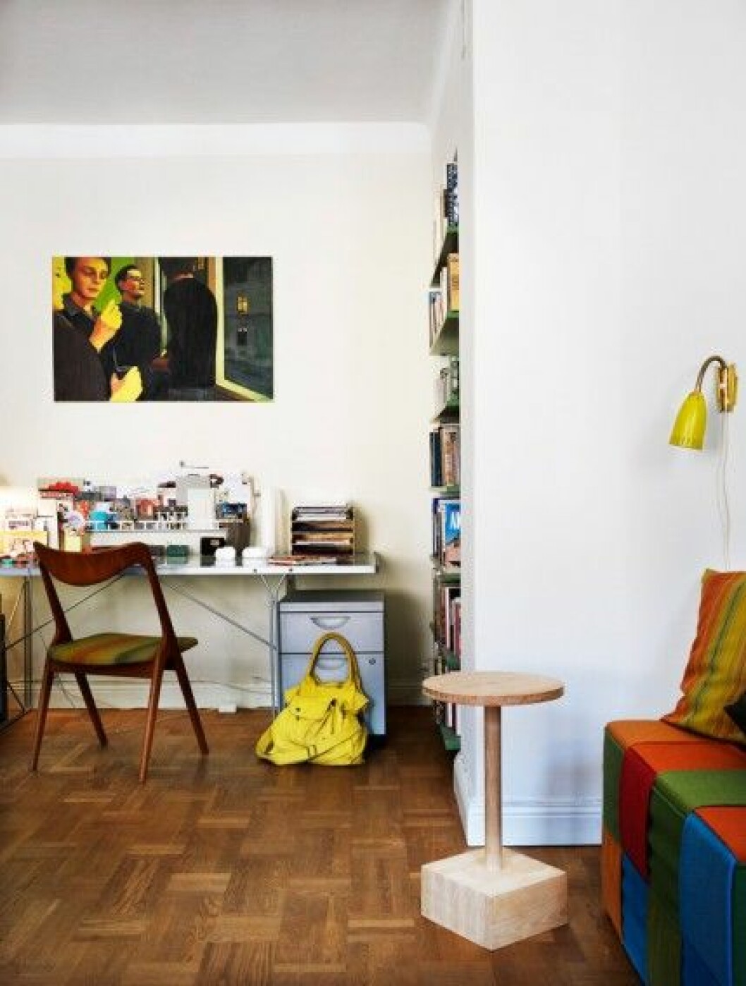 Glasbord och grå hurts från Ikea. Secondhandstol med sits klädd i tyget <em>Spectra</em>. Målningen på väggen är gjord av ena dottern, Tove Edlund Dreiman. vardagsrum-arbetsplats-inbyggd-bokhylla-foto-Patric-Johansson