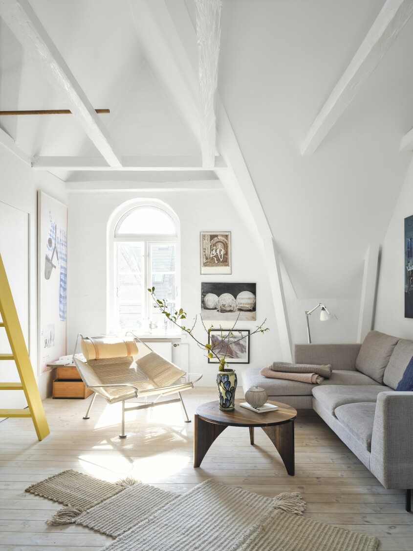 Det välvda taket ger rummet en katedralliknande känsla. Soffan är designad av Niels Gammelgaard. Fåtölj av Hans J. Wegner. Soffbord av Helles make Lars Oxfeldt Mortensen. Vasen på soffbordet är från Kähler. Lampan är från Luceplan och mattan från Kusiner. På väggen hänger ett porträtt av Rikke Baumgarten och Helle Hestehave, av fotografen Jette Jørs och målningen Spare parts for the universe av Nicolai Østergaard, samt ett foto av Lars Oxfeldt Mortensen. Det stora hästkonstverket på den vänstra väggen är av Troels Wörsel. Vardagsrum