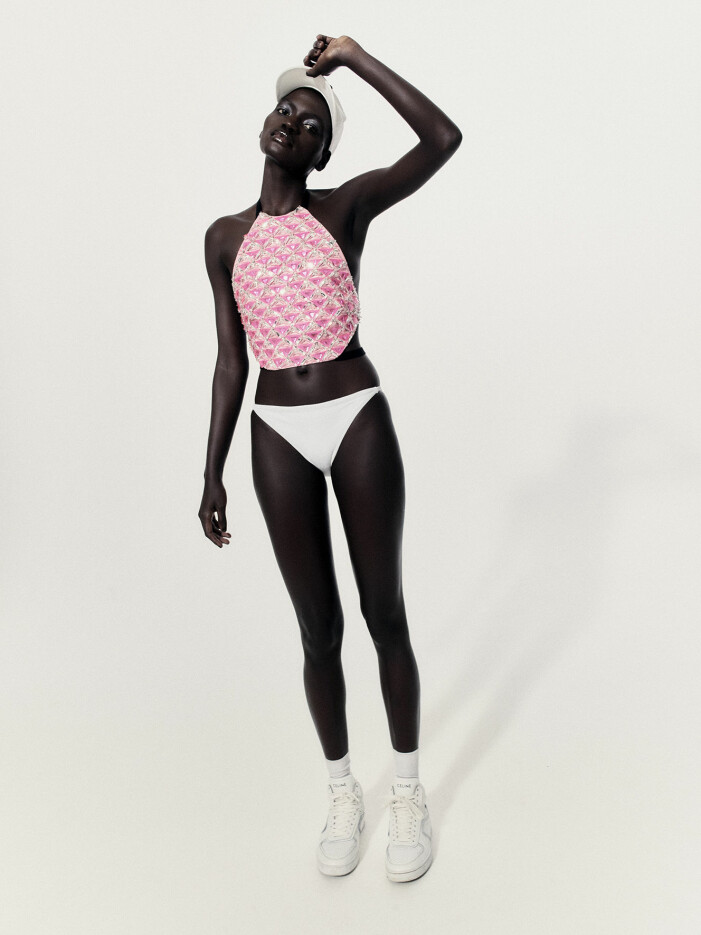 Topp, pris vid förfrågan, Miu Miu. Bikinitrosa, 250 kr, COS. Strumpor, 49 kr, Arket. Keps, 3 550 kr, och sneakers, 7 500 kr, båda Celine by Hedi Slimane. Modellen har en rosa topp, vit bikinitrosa och vita sneakers