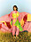 Modellen har på sig en rosa och gul skjorta och byxa båda ÀLG med en grön klänning under från Agilitá