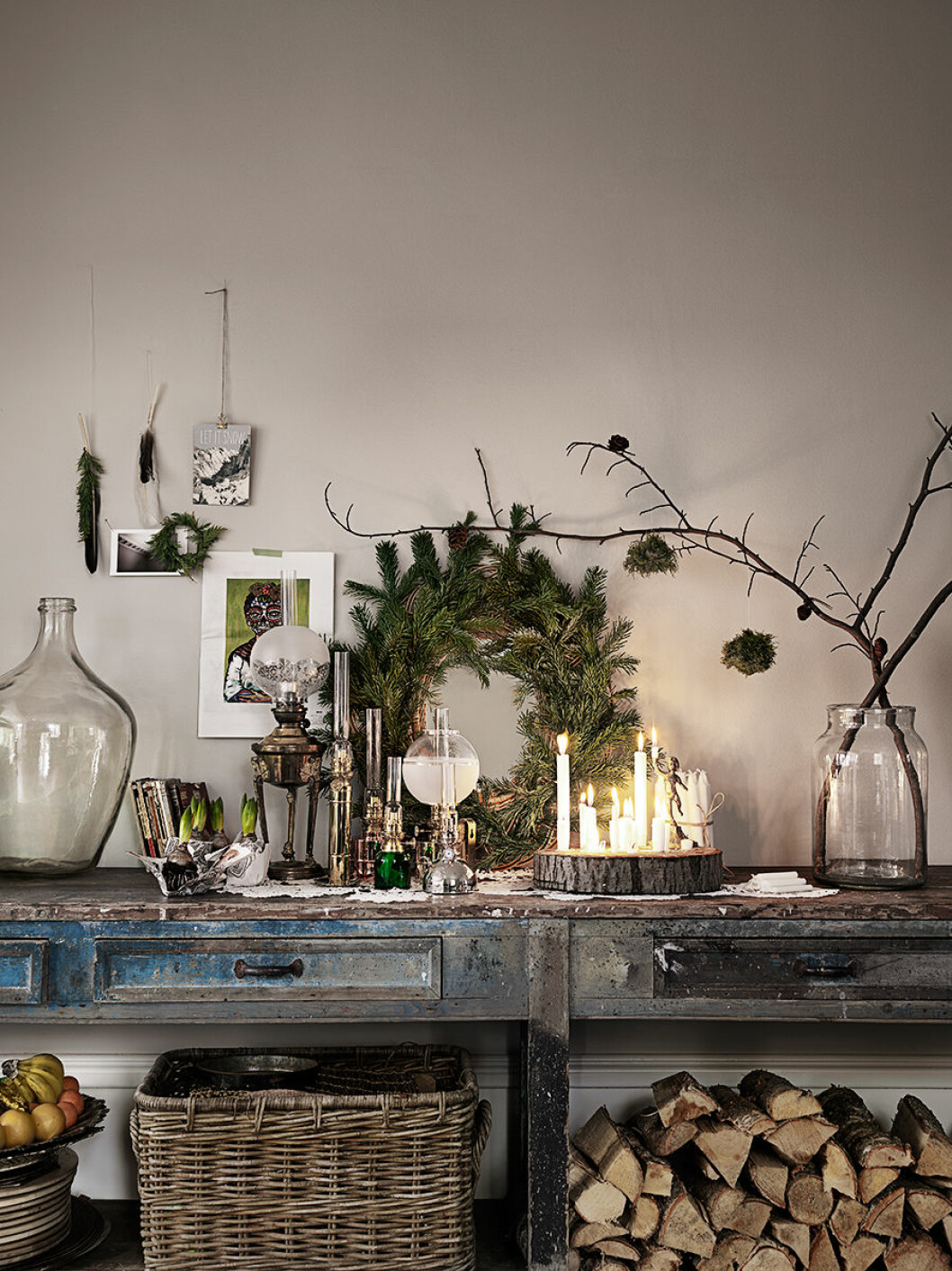 Arbetsbänk med julkrans och stilleben av olika ljus