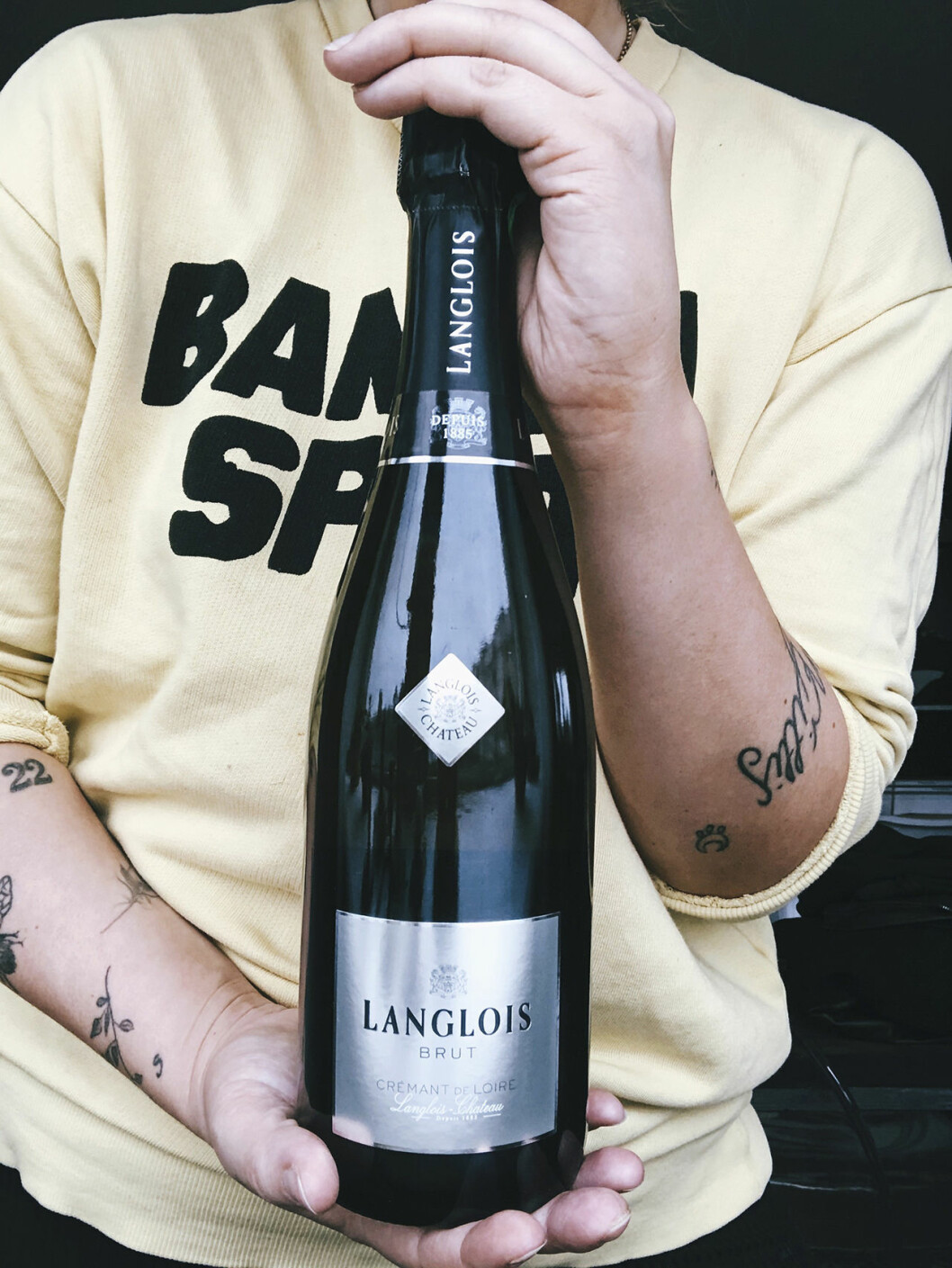 Emas bästa tips är att prova nytt och föra anteckningar för att lära sig mer om vin. Bild kvinna med vinflaska