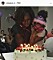 EN kvinna håller ett barn och de blåser ut ljus på en tårta