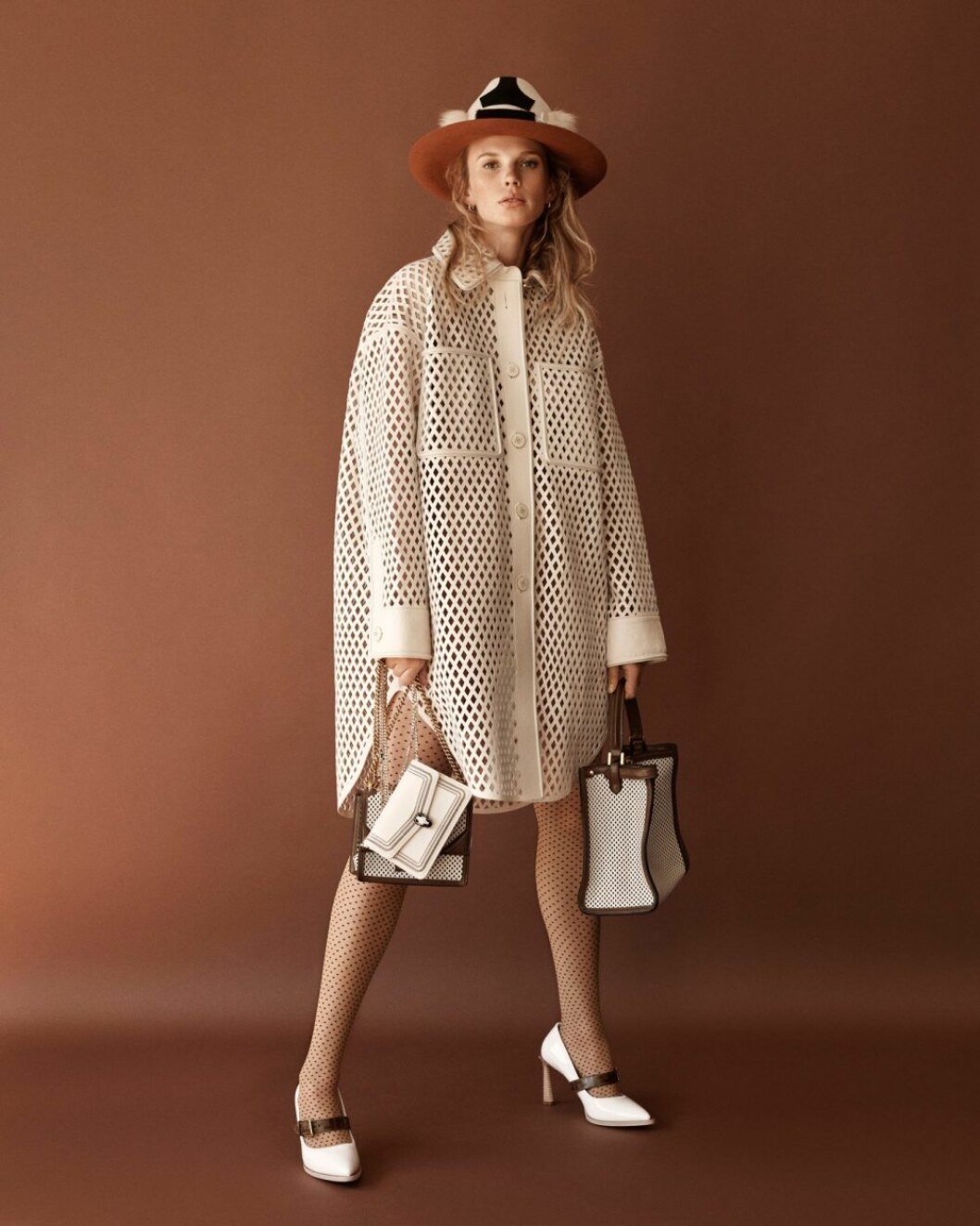 Läderkappa, 70 580 kr, skor, 9 940 kr, väska, Peekaboo medium, 37 430 kr, och väska, Can u small, 21 030 kr, allt Fendi. Hatt, 4 595 kr, Muehlbauer. Större hatt, pris vid förfrågan, Kreisi couture. Väska, Serpenti diamond blast, 18 725 kr, Bvlgari. Strumpbyxor, 210 kr, Calzedonia. Vit läderkappa med håliga detaljer från Bvlgari