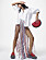 Fotomodellen har på sig en vit skjorta från Dior, en kjol med fransar från Missoni, tillsammans med röda skor och väska från Jw Anderson